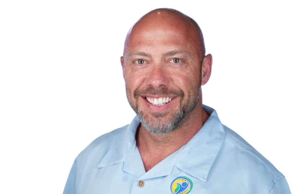 Lee wearing a light blue shirt with a logo of the Holistic Wellness Center