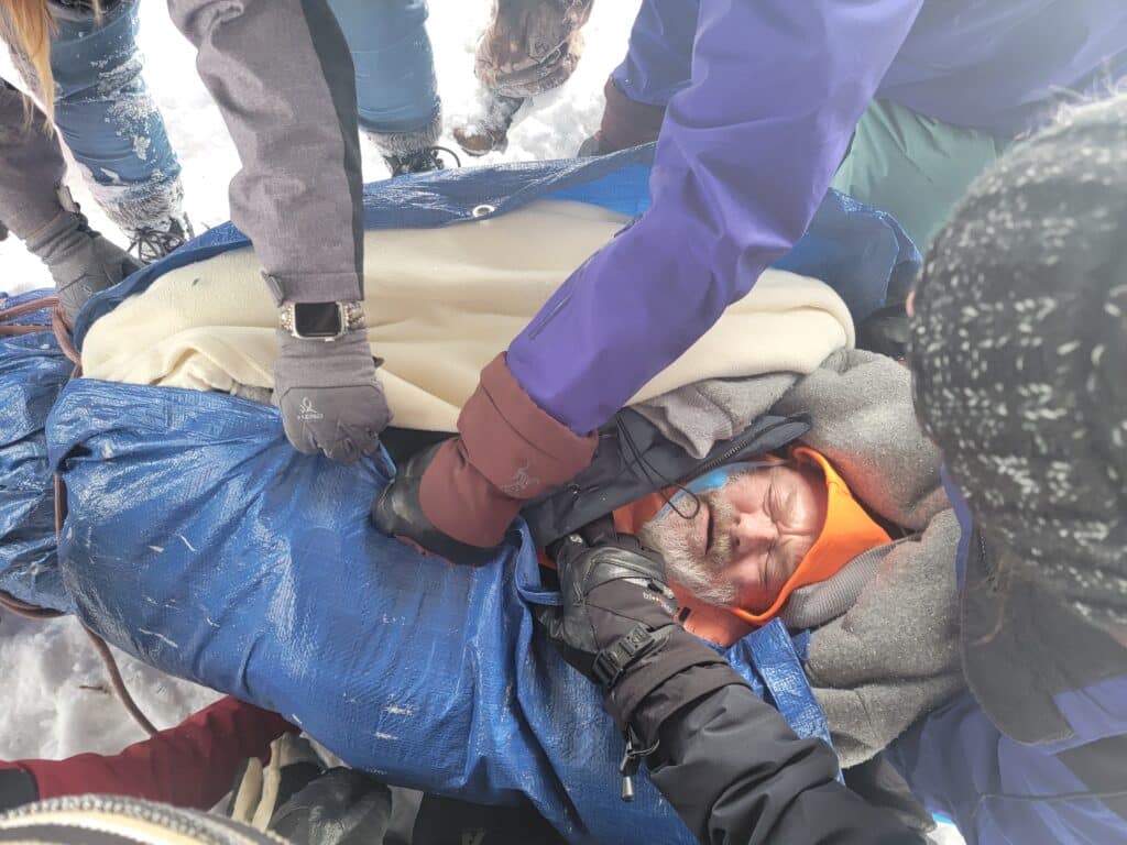 A man in cold getting helping hands from people